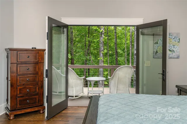 a bedroom with a bed and large windows