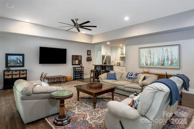 a living room with furniture a ceiling fan and a flat screen tv