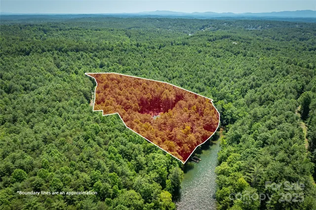 an aerial view of a house with a yard and lake view