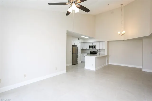 a view of kitchen with kitchen island white cabinets and refrigerator