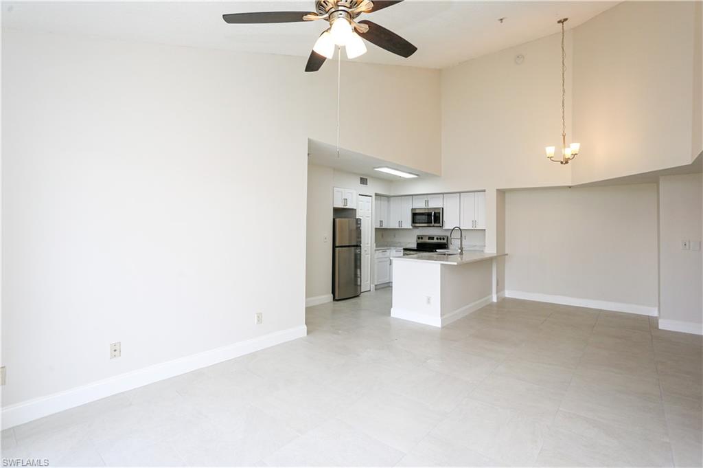 1265 Wildwood Lakes Boulevard, Unit 3306 Naples, FL 34104 - Photo 12 of 39 a view of kitchen with kitchen island white cabinets and refrigerator