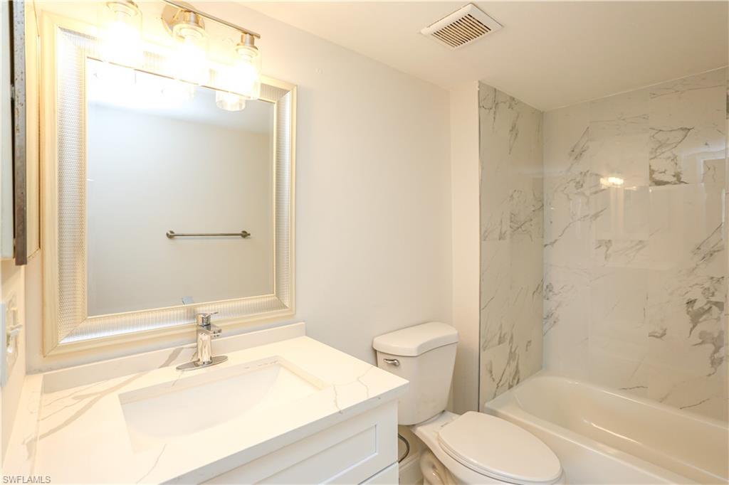 1265 Wildwood Lakes Boulevard, Unit 3306 Naples, FL 34104 - Photo 20 of 39 a bathroom with a sink toilet vanity and shower