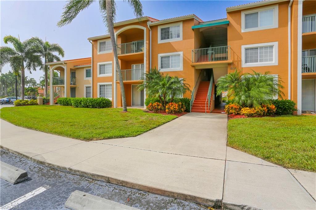 1265 Wildwood Lakes Boulevard, Unit 3306 Naples, FL 34104 - Photo 2 of 39 a view of a building with a yard