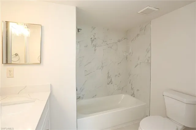 a white bath tub sitting next to a white toilet