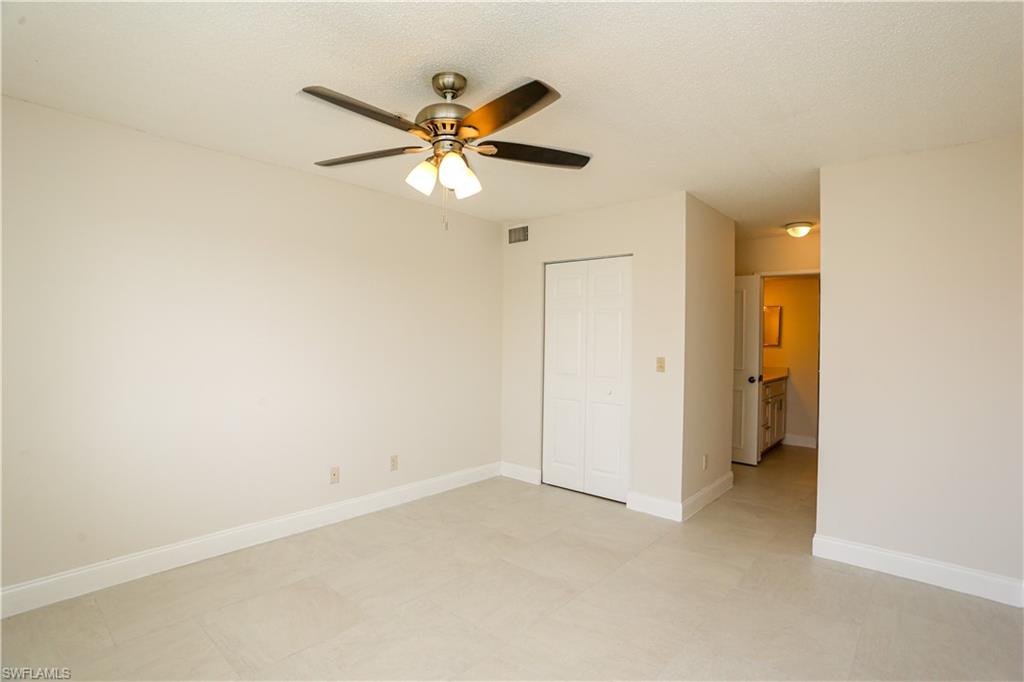 1265 Wildwood Lakes Boulevard, Unit 3306 Naples, FL 34104 - Photo 28 of 39 an empty room with a ceiling fan and a window