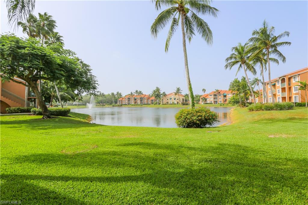 1265 Wildwood Lakes Boulevard, Unit 3306 Naples, FL 34104 - Photo 35 of 39 a view of a lake with a big yard and palm trees