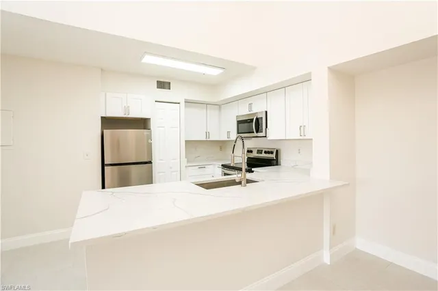 a kitchen with a refrigerator a stove a microwave and cabinets