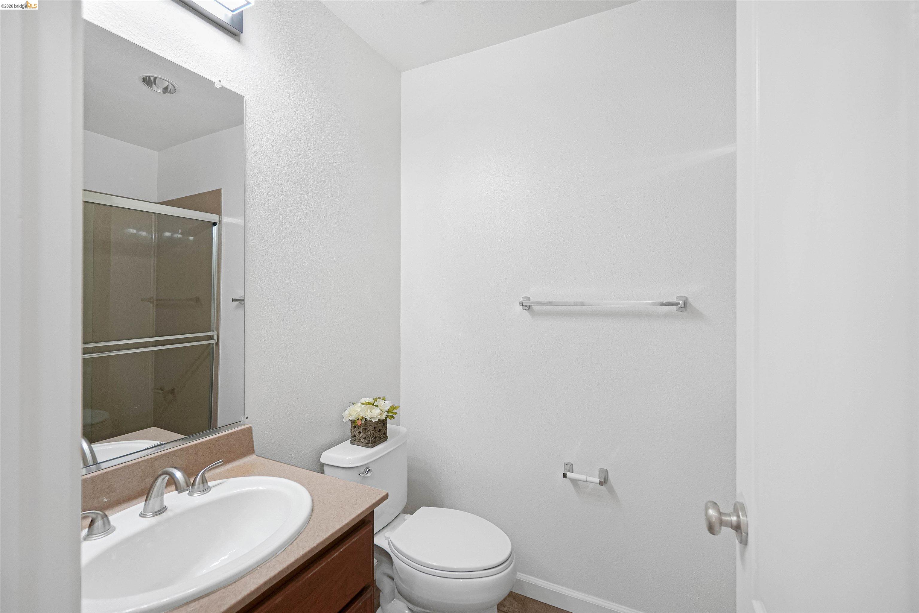 449 Constantine Court San Ramon, CA 94583 - Photo 51 of 63 Bathroom featuring a shower with sliding glass doors, a vanity with an integrated sink, a toilet, and a wall-mounted towel bar