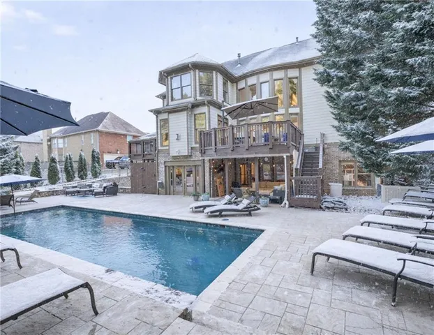 a view of kitchen with stainless steel appliances kitchen island granite countertop a table chairs in it and wooden floor