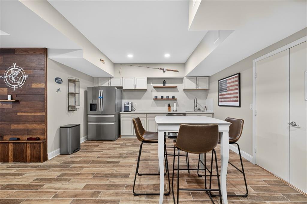 909 Pathview Court Dacula, GA 30019 - Photo 75 of 113 a kitchen with stainless steel appliances a dining table chairs refrigerator and sink