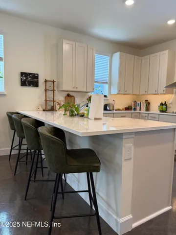 a metallic refrigerator freezer and a stove sitting inside of a kitchen