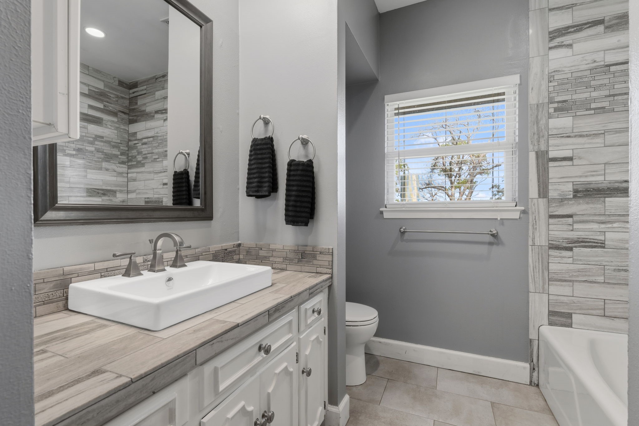 2935 West Fm 1462 Rosharon, TX 77583 - Photo 24 of 50 This photo features a stylishly updated bathroom with a clean, contemporary design. The space includes a white vanity with a modern vessel sink, sleek fixtures, and ample storage below.