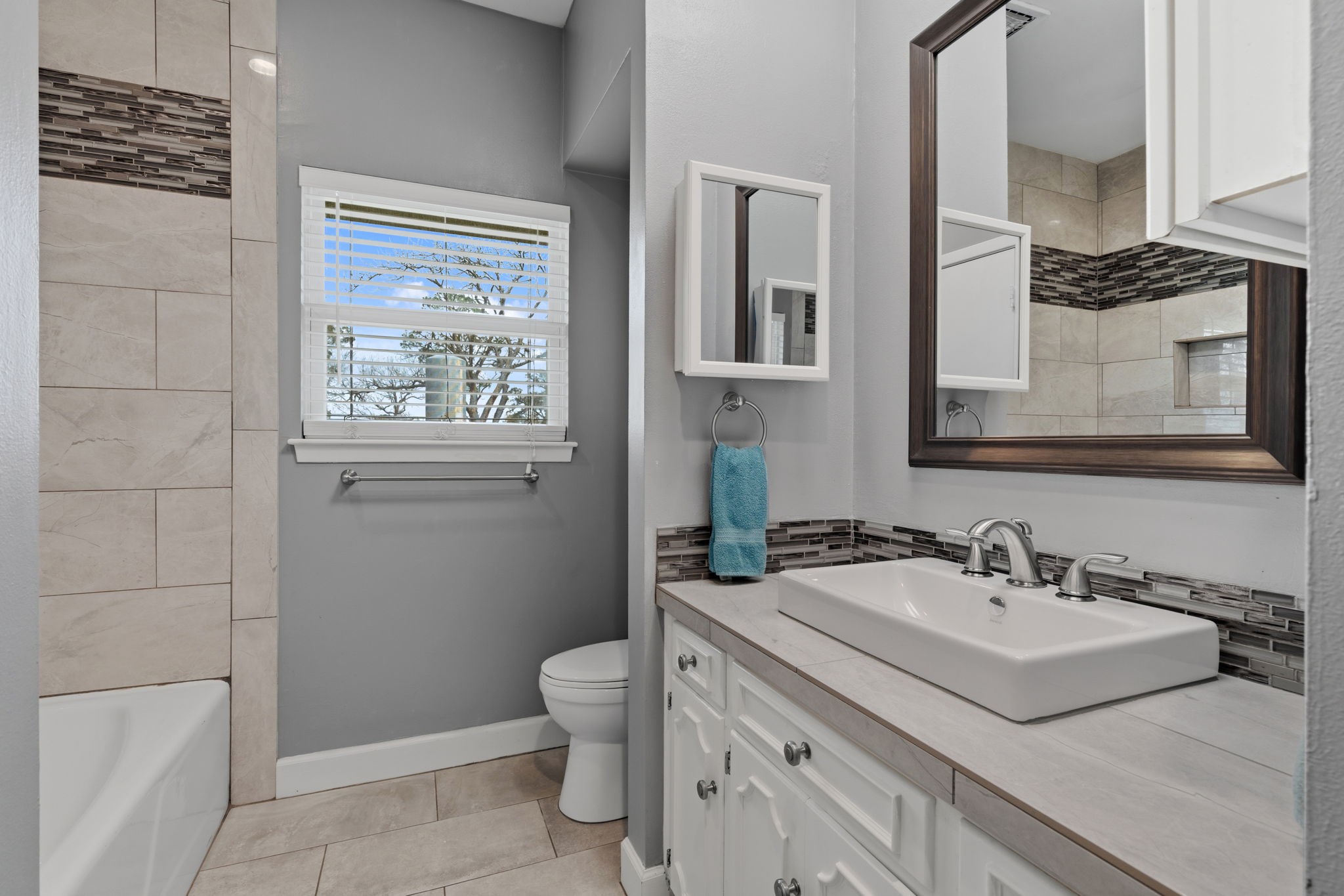 2935 West Fm 1462 Rosharon, TX 77583 - Photo 29 of 50 This photo showcases a well-appointed bathroom with a clean, modern feel. The space features a white vanity topped with a vessel sink and sleek chrome fixtures, complemented by a large framed mirror and coordinating accent mirror.