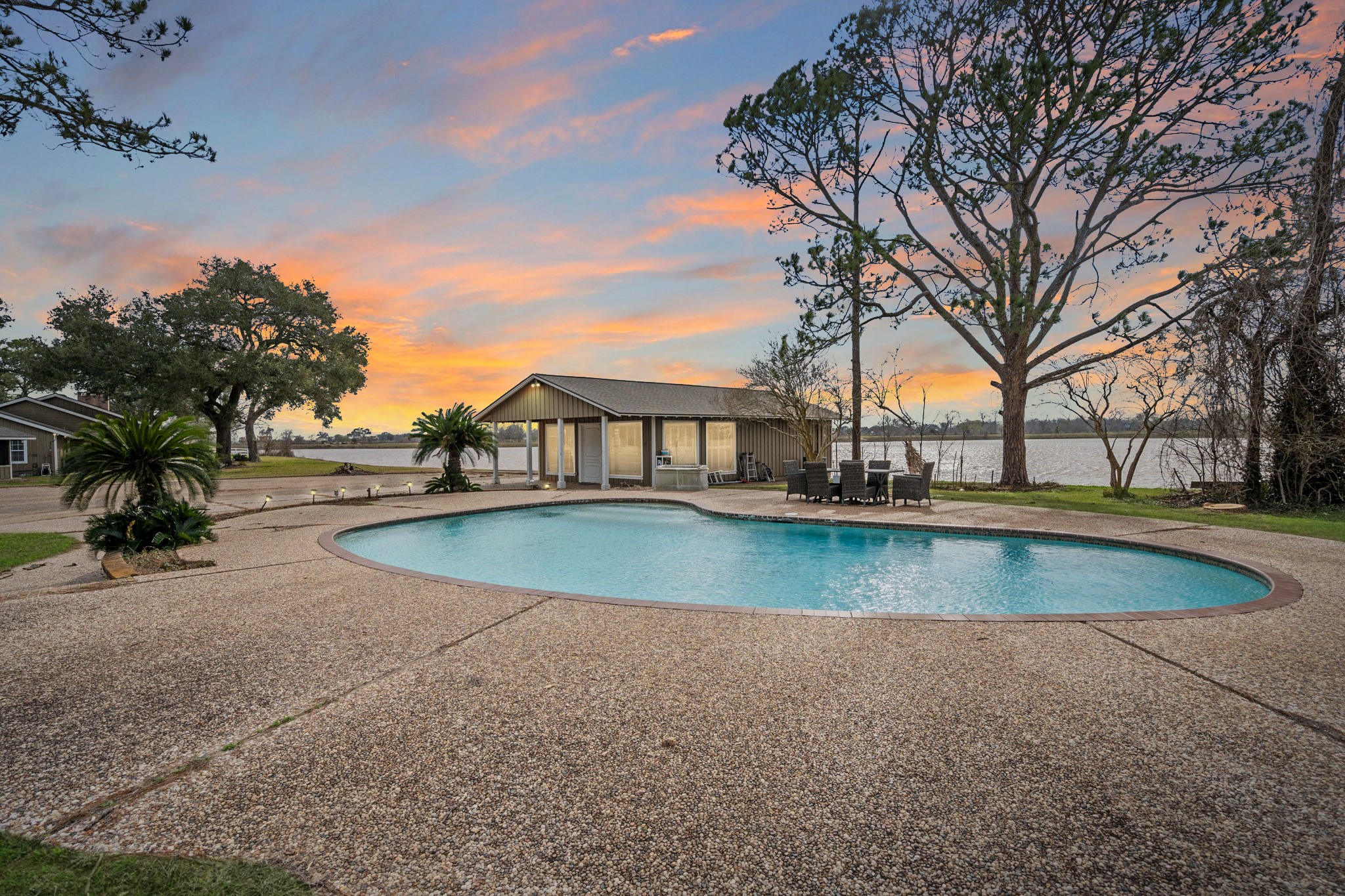 2935 West Fm 1462 Rosharon, TX 77583 - Photo 38 of 50 This stunning outdoor retreat captures the true spirit of ranch living, anchored by an expansive, resort-style pool that invites long days of relaxation and entertaining. The generous pool deck offers plenty of space for gathering, lounging, and taking in the peaceful surroundings. Just beyond the water, the pool house provides a convenient and welcoming hub for guests, seamlessly blending function with comfort.