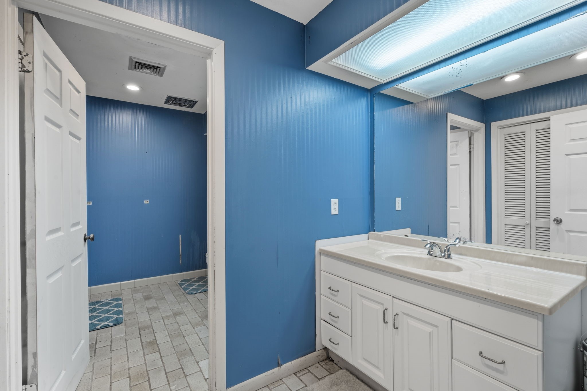 2935 West Fm 1462 Rosharon, TX 77583 - Photo 45 of 50 This bathroom features a spacious vanity area with a wide countertop, integrated sink, and ample cabinet storage below. A large mirror with overhead lighting brightens the space and enhances functionality.