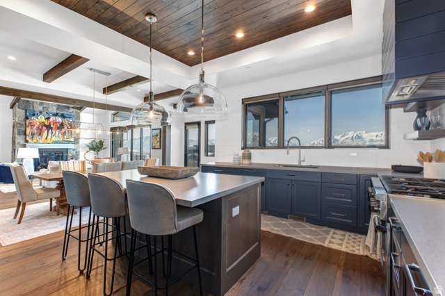 1282 Chimney Rock Road, Unit 344 Heber City, UT 84032 - Photo 19 of 55 Gourmet kitchen featuring a wood-panel ceiling, spacious island with seating, dark-finish cabinetry, built-in range, and a mountain backdrop visible through multiple windows