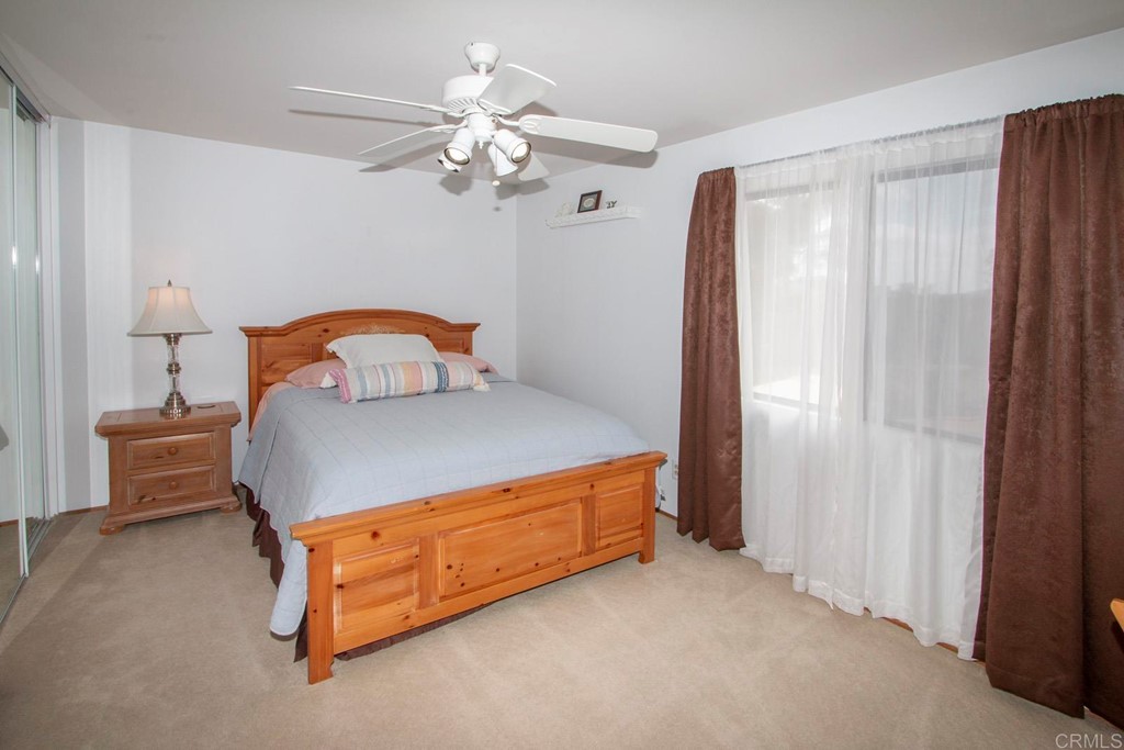 14866 Oakline Road Poway, CA 92064 - Photo 27 of 49 a bedroom with a bed and a chandelier