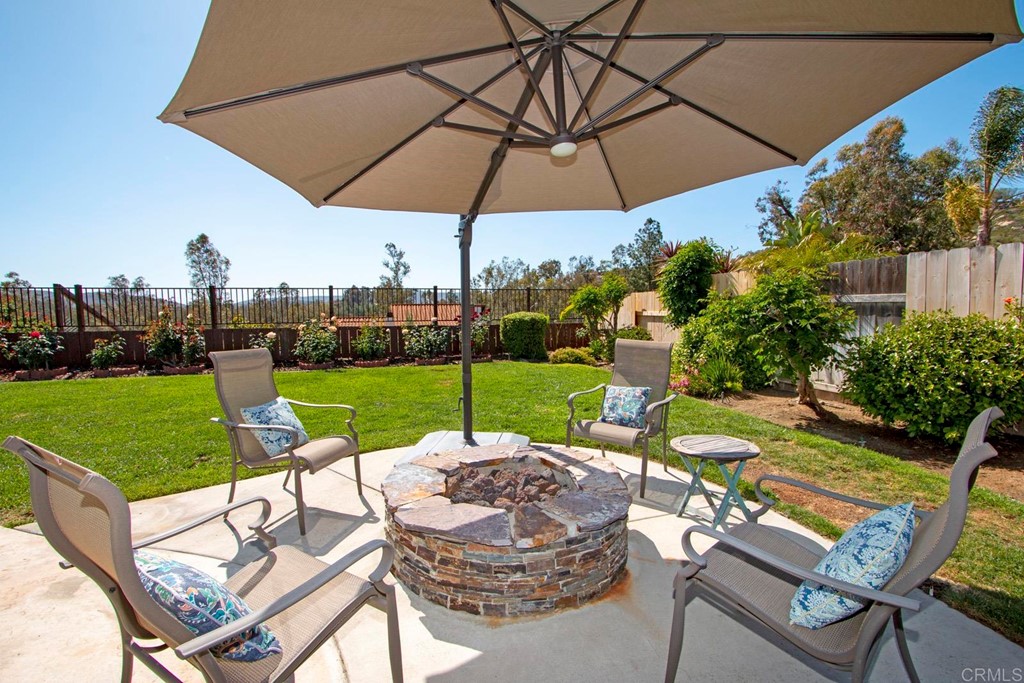 14866 Oakline Road Poway, CA 92064 - Photo 41 of 49 a view of a patio with a table chairs and a umbrella