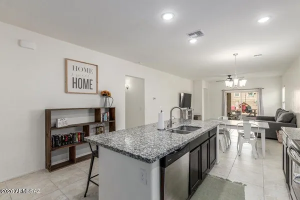 a kitchen with stainless steel appliances granite countertop a sink stove microwave and refrigerator