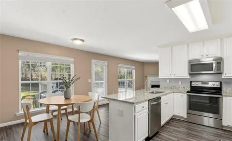 a kitchen with a table chairs stove and cabinets