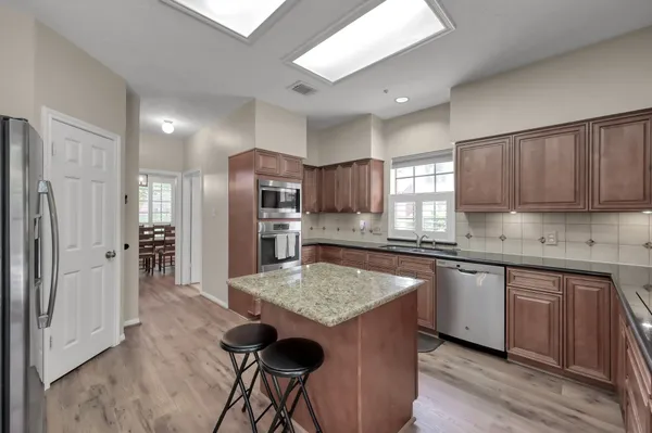 a kitchen with stainless steel appliances granite countertop a sink stove and refrigerator