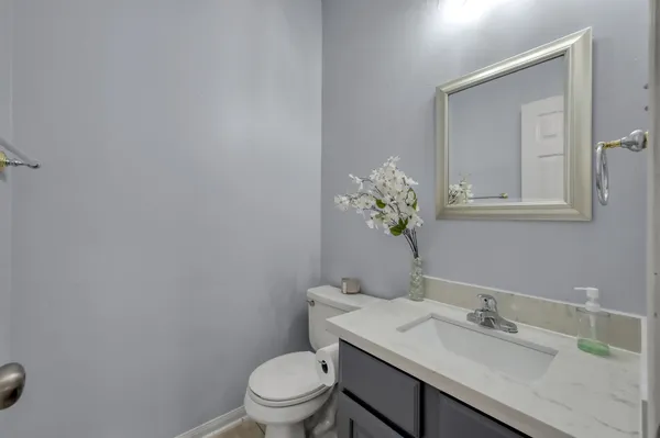 a bathroom with a granite countertop sink a toilet and mirror