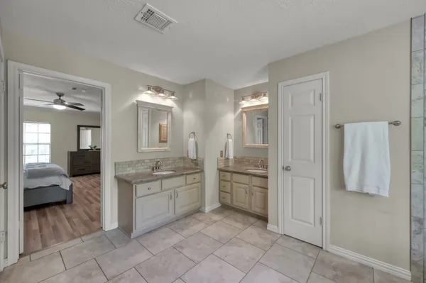 a spacious bathroom with a granite countertop sink mirror and a shower
