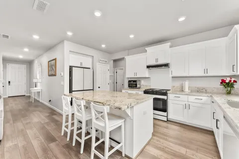 a large white kitchen with cabinets and sink