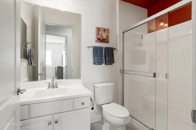 a bedroom with a bed and a mirror on dresser