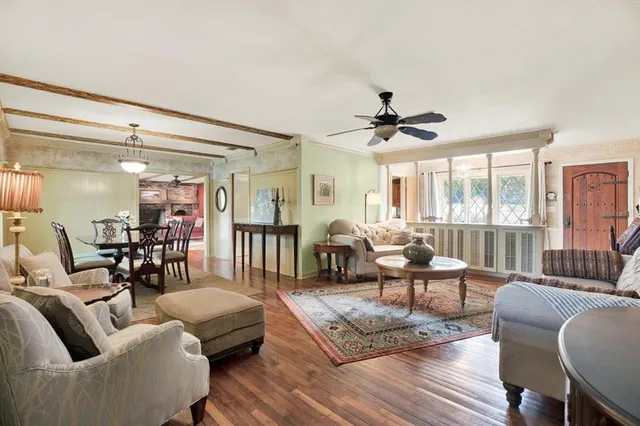 a living room with furniture and a large window with wooden floor