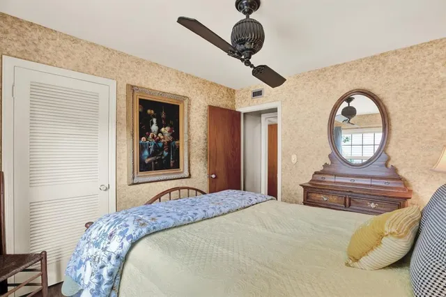 a bedroom with a bed and dresser with mirror