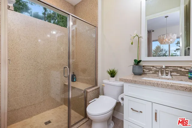 a kitchen with kitchen island a large counter top space a sink stainless steel appliances and windows