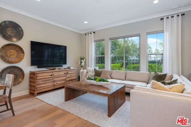 a living room with furniture a table and kitchen view