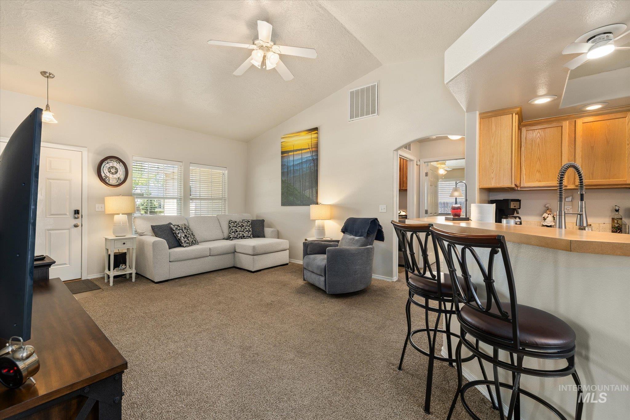 5401 Barkley Way Caldwell, ID 83607 - Photo 17 of 35 Open-concept living space featuring vaulted ceilings, a ceiling fan, and carpet flooring