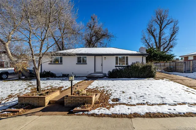 a view of a house with snow on the side of the road