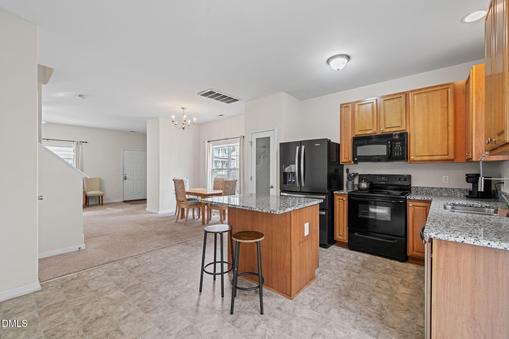 5841 Wynmore Road Raleigh, NC 27610 - Photo 13 of 40 a kitchen with stainless steel appliances granite countertop a stove top oven a refrigerator a sink dishwasher with a dining table and chairs