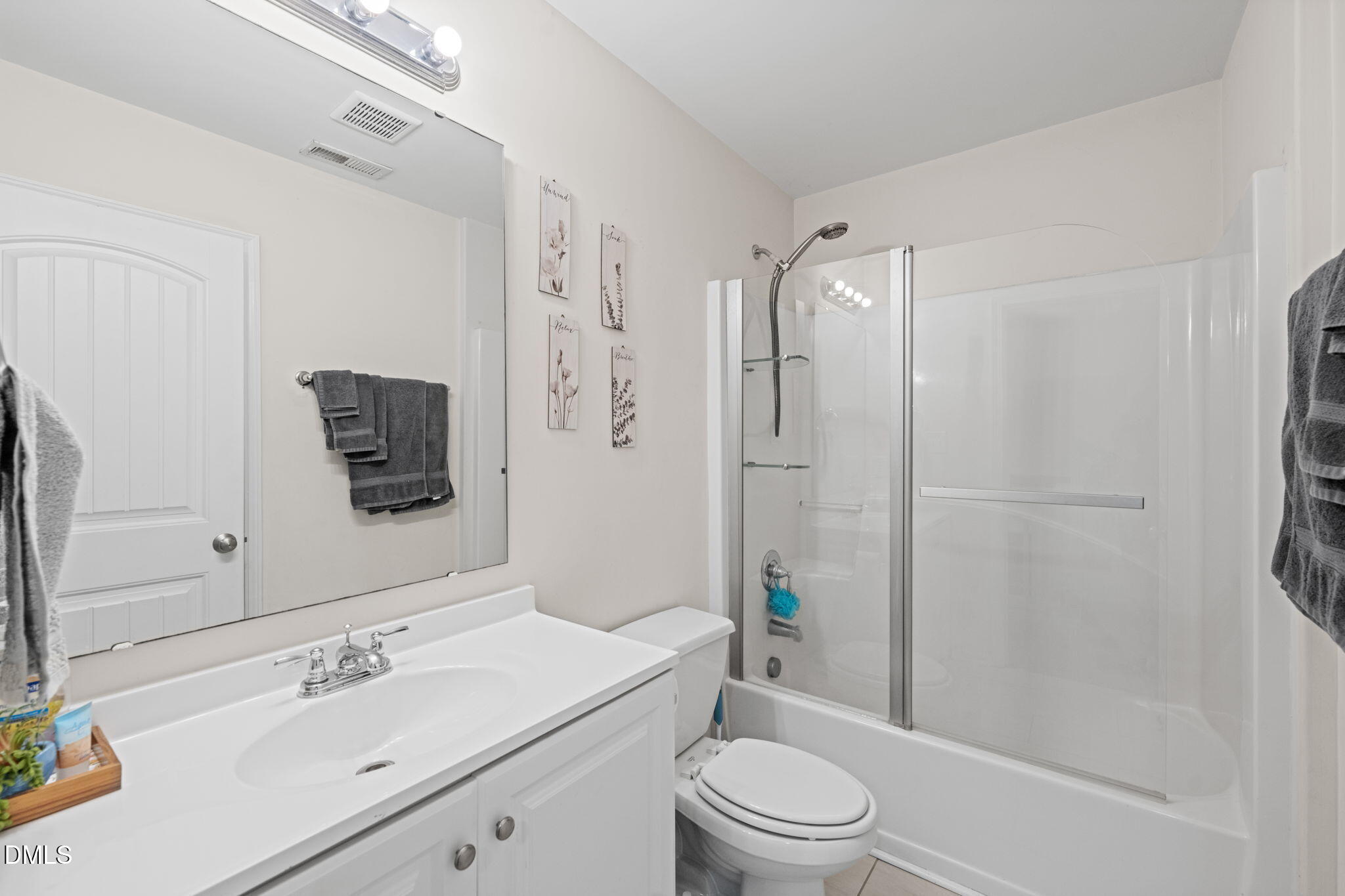 5841 Wynmore Road Raleigh, NC 27610 - Photo 27 of 40 a bathroom with a sink a toilet a mirror a vanity and shower