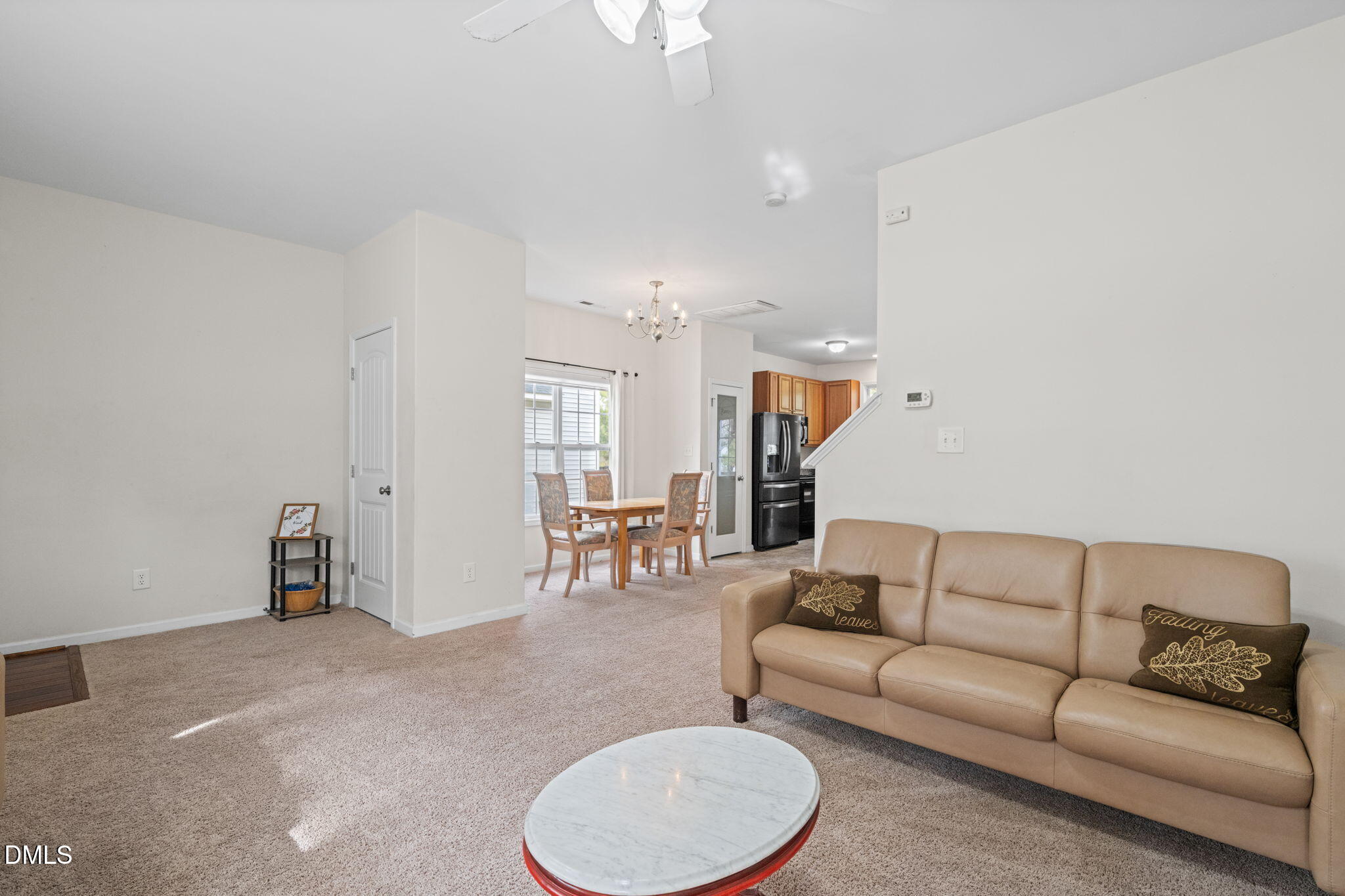 5841 Wynmore Road Raleigh, NC 27610 - Photo 5 of 40 a living room with furniture and a dining table with chandelier