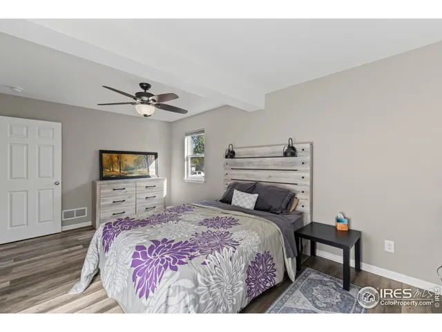 a bedroom with a bed a dresser and potted plants