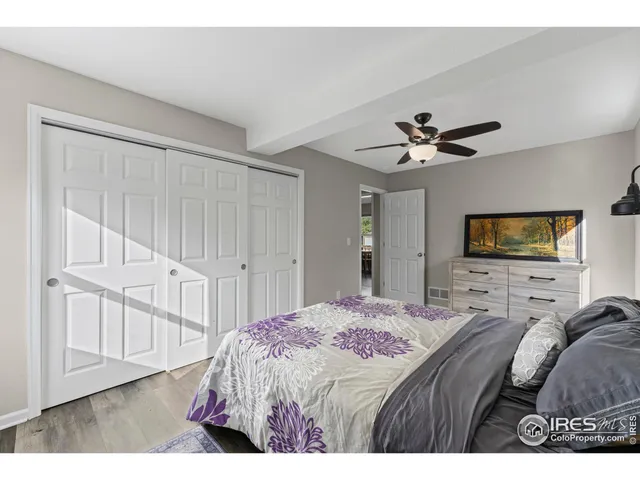 a bedroom with a bed a chandelier and a flat screen tv