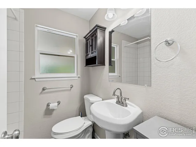a bathroom with a toilet a sink and mirror
