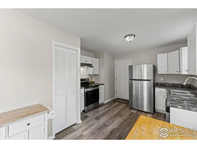 a kitchen with refrigerator cabinets and wooden floor