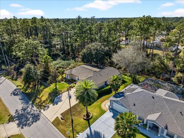 a front view of house with yard and trees in the background