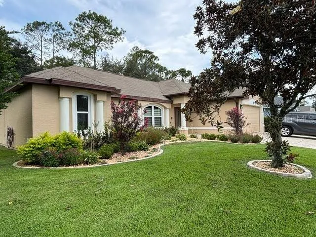a front view of house with yard and trees around