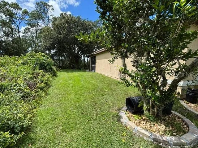 a view of a house with a big yard and potted plants