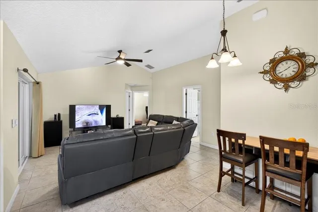 a living room with furniture a chandelier and a flat screen tv