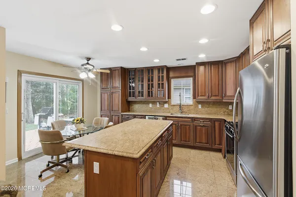 a kitchen with kitchen island granite countertop a sink stove and refrigerator