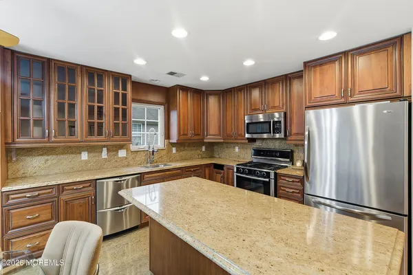 a kitchen with granite countertop stainless steel appliances and wooden cabinets