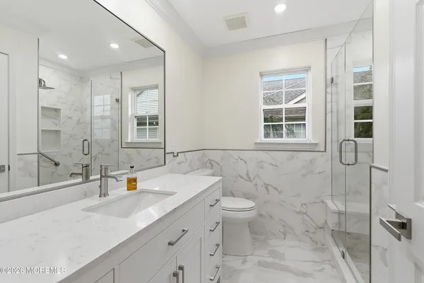 a bathroom with a double vanity sink toilet and shower