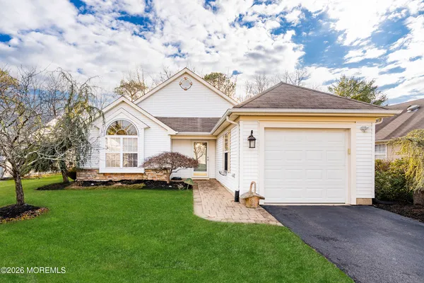 a front view of a house with a garden and yard